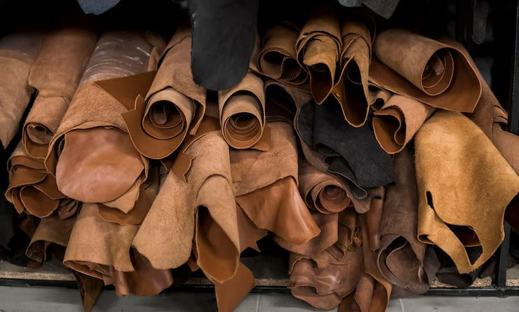 Stack of rolled leather hides in various shades of brown - Westo Leather